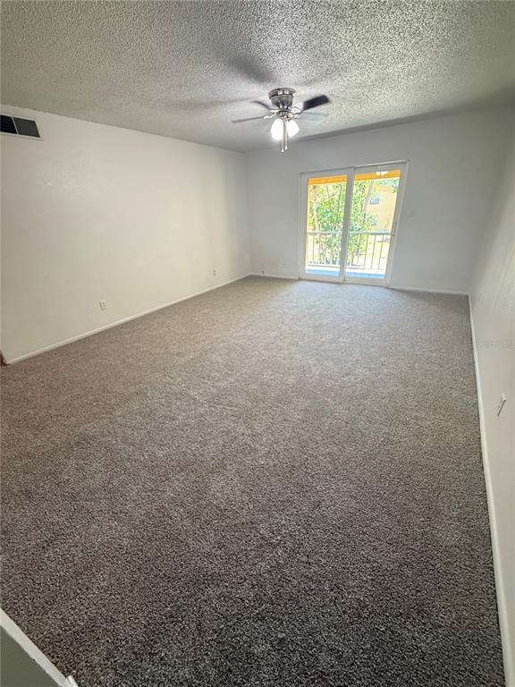 an empty room with windows and ceiling fan view