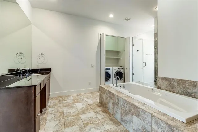 a spacious bathroom with a bathtub sink and mirror