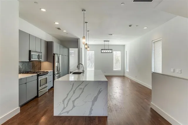 a large kitchen with cabinets wooden floor and stainless steel appliances