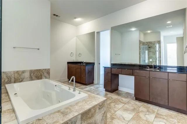 a bathroom with a tub sink and mirror
