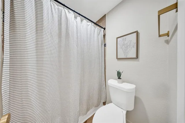 a white toilet sitting next to a white wooden roof