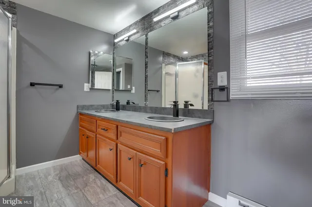 a bathroom with double sink and a mirror