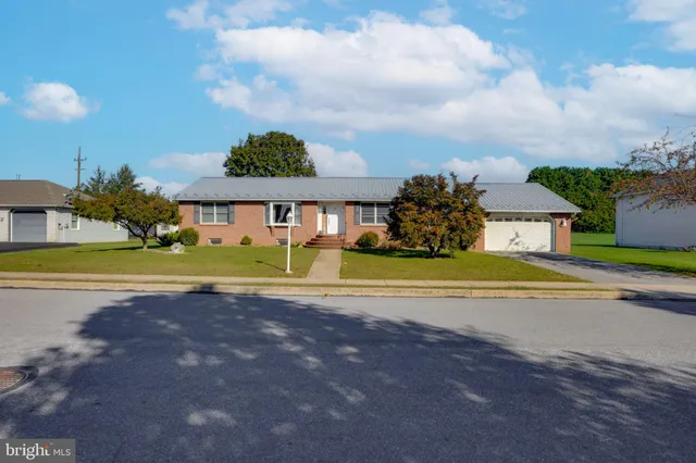 a view of a house with a big yard and large trees