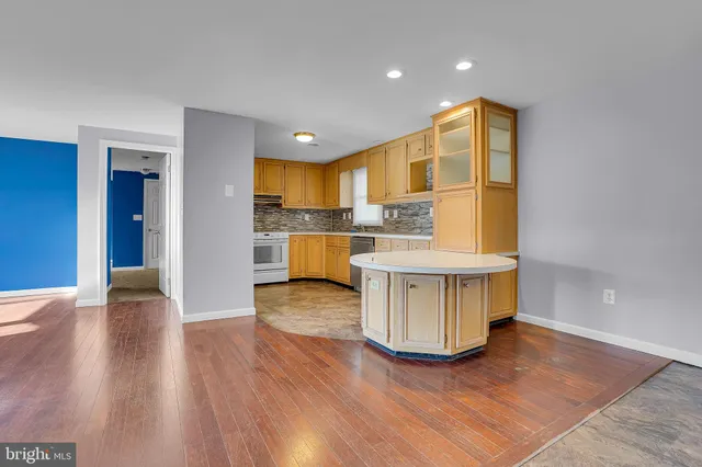 a view of a kitchen with kitchen island a sink wooden floor and a counter top space