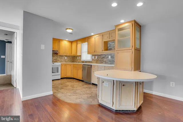 a kitchen with a wooden floor and a refrigerator