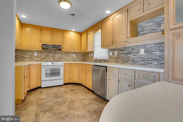 a kitchen with stainless steel appliances granite countertop a sink a stove and cabinets
