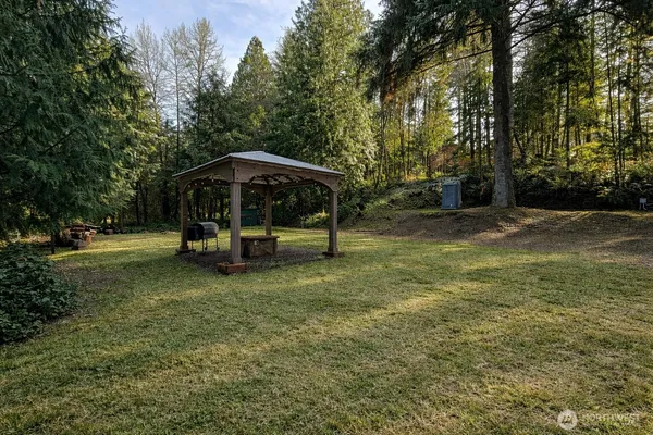 a view of a park with large trees and a barn