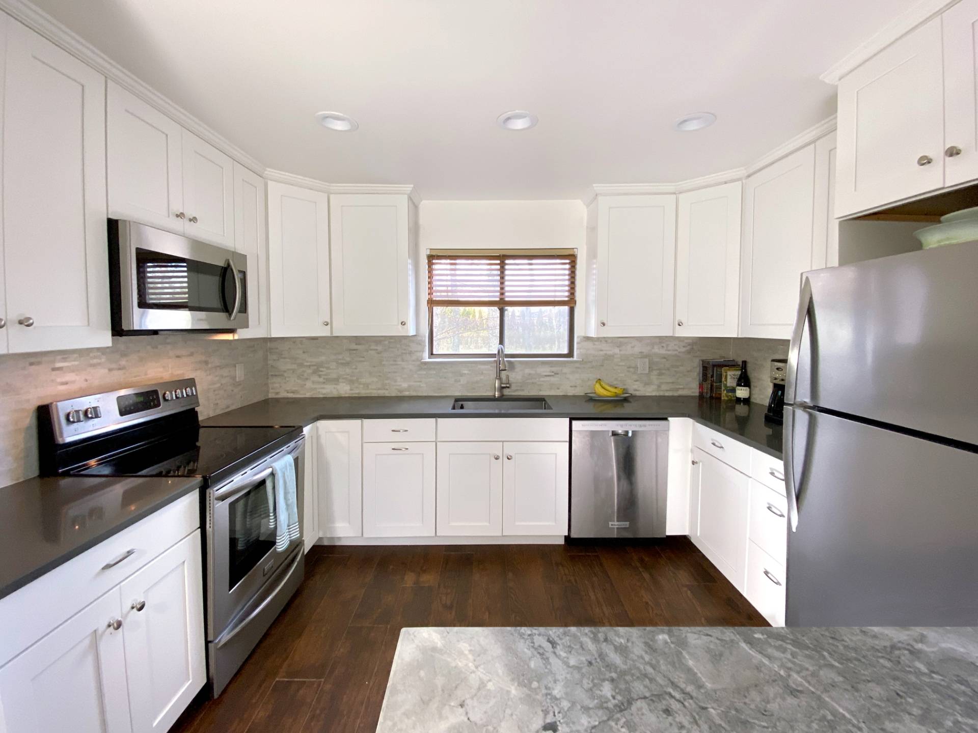 4 Renees Way East Hampton, NY 11937 - Photo 3 of 16 a kitchen with granite countertop white cabinets and white appliances
