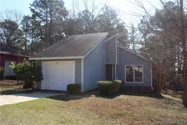 a view of a house with a yard and garage