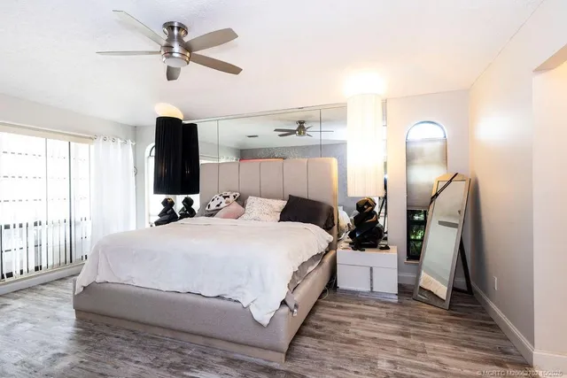 a bedroom with a bed and a mirror on the dresser