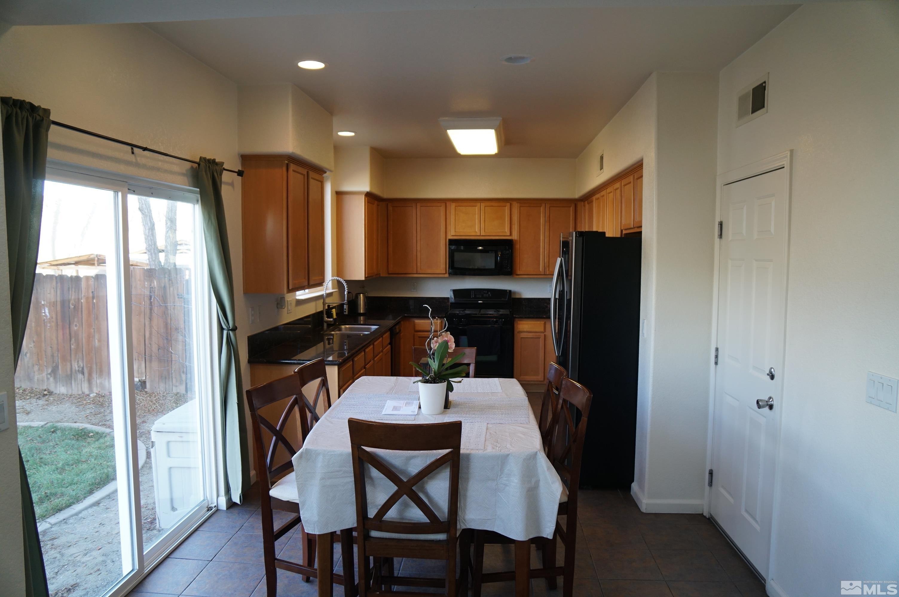 2120 Hellaby Lane Reno, NV 89502 - Photo 18 of 21 a kitchen with a table chairs refrigerator and microwave