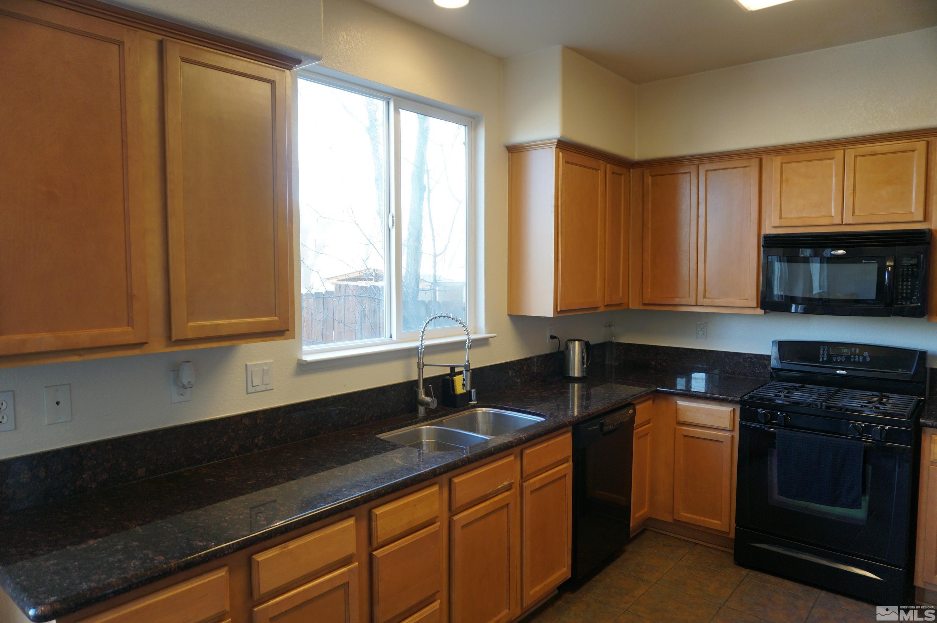 2120 Hellaby Lane Reno, NV 89502 - Photo 20 of 21 a kitchen with granite countertop a stove a sink and a microwave