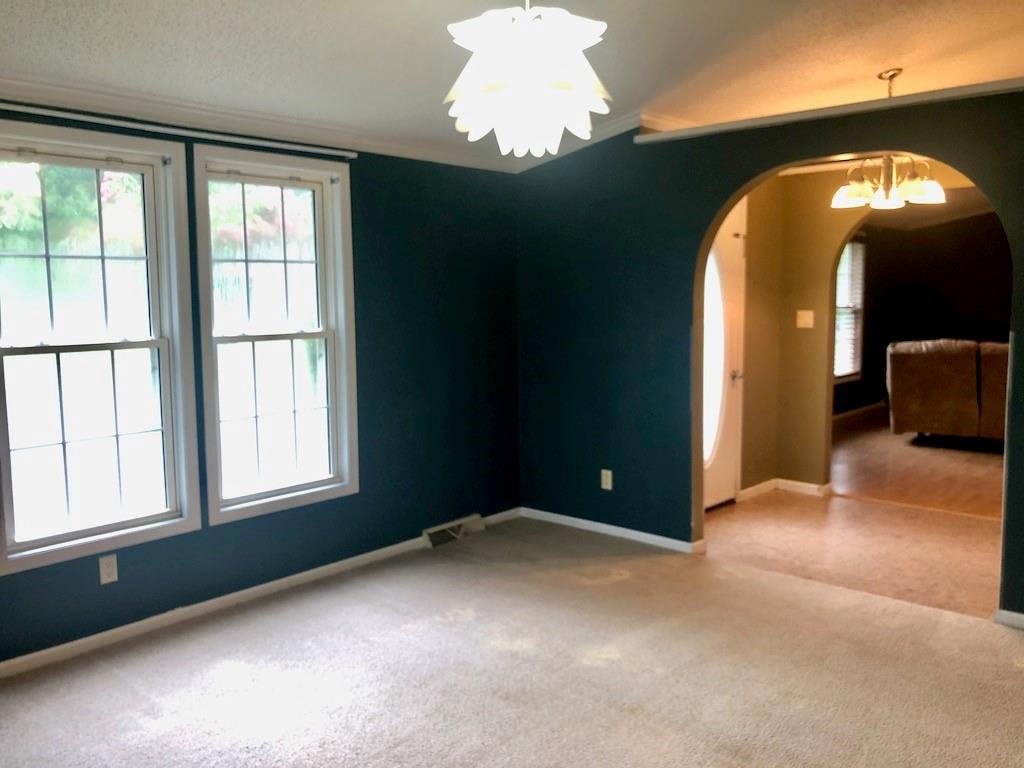 340 Ridge Road Mocksville, NC 27028 - Photo 7 of 22 an empty room with windows and chandelier