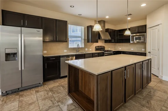 a kitchen with stainless steel appliances a sink stove top oven and cabinets