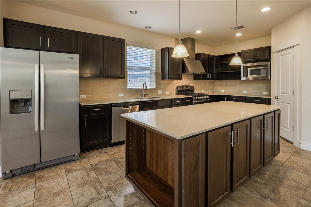 825 Clear Stream Crossing Austin, TX 78753 - Photo 13 of 34 a kitchen with a sink a counter top space stainless steel appliances and cabinets