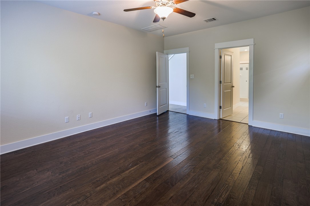 825 Clear Stream Crossing Austin, TX 78753 - Photo 20 of 34 an empty room with wooden floor and a ceiling fan