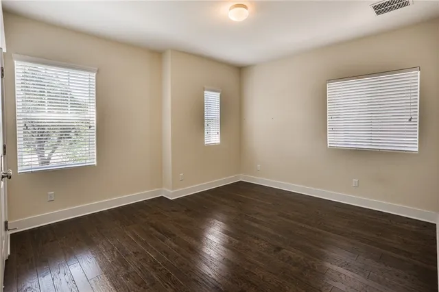 an empty room with wooden floor and window