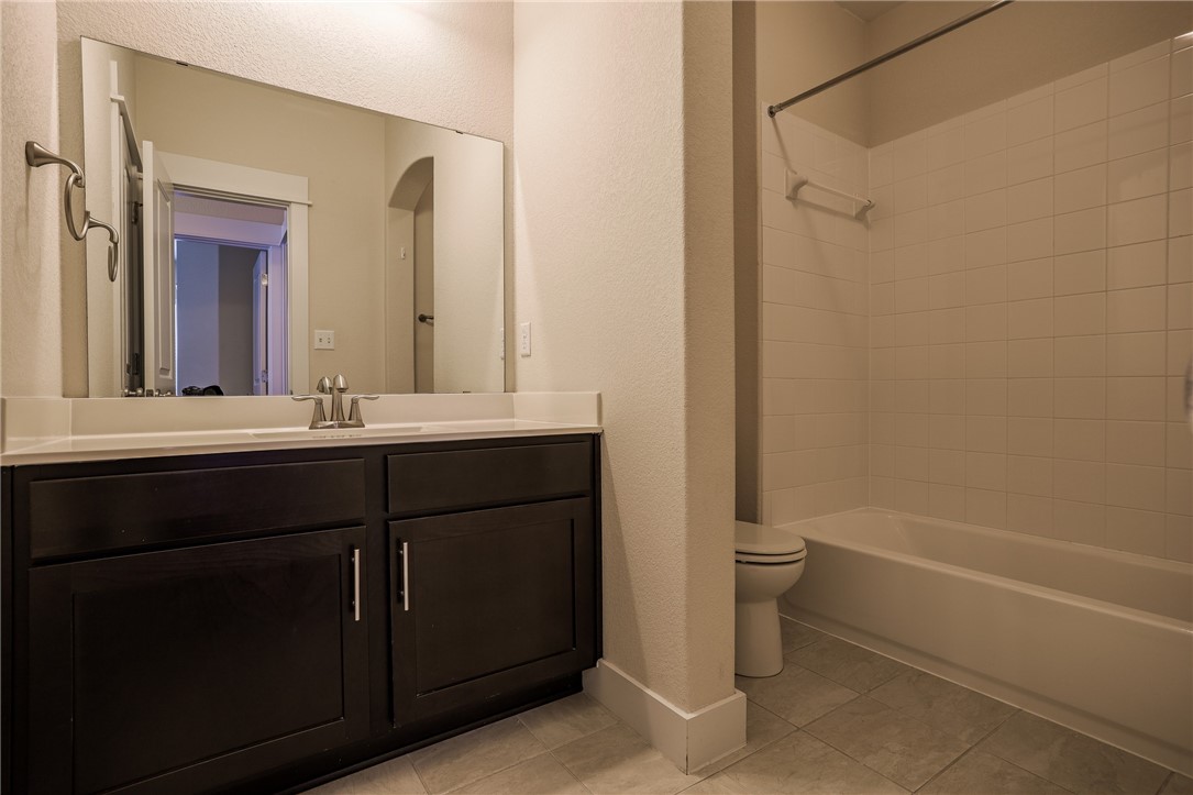 825 Clear Stream Crossing Austin, TX 78753 - Photo 29 of 34 a bathroom with a double vanity sink toilet and shower