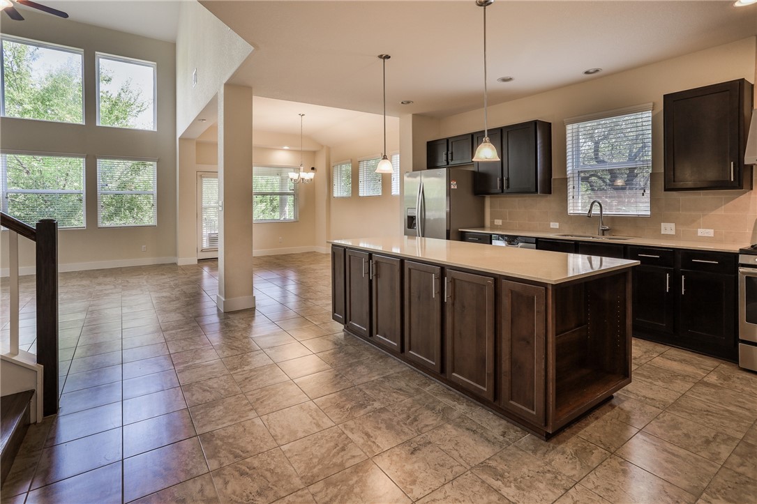 825 Clear Stream Crossing Austin, TX 78753 - Photo 10 of 34 a kitchen with a sink a counter top space cabinets and stainless steel appliances