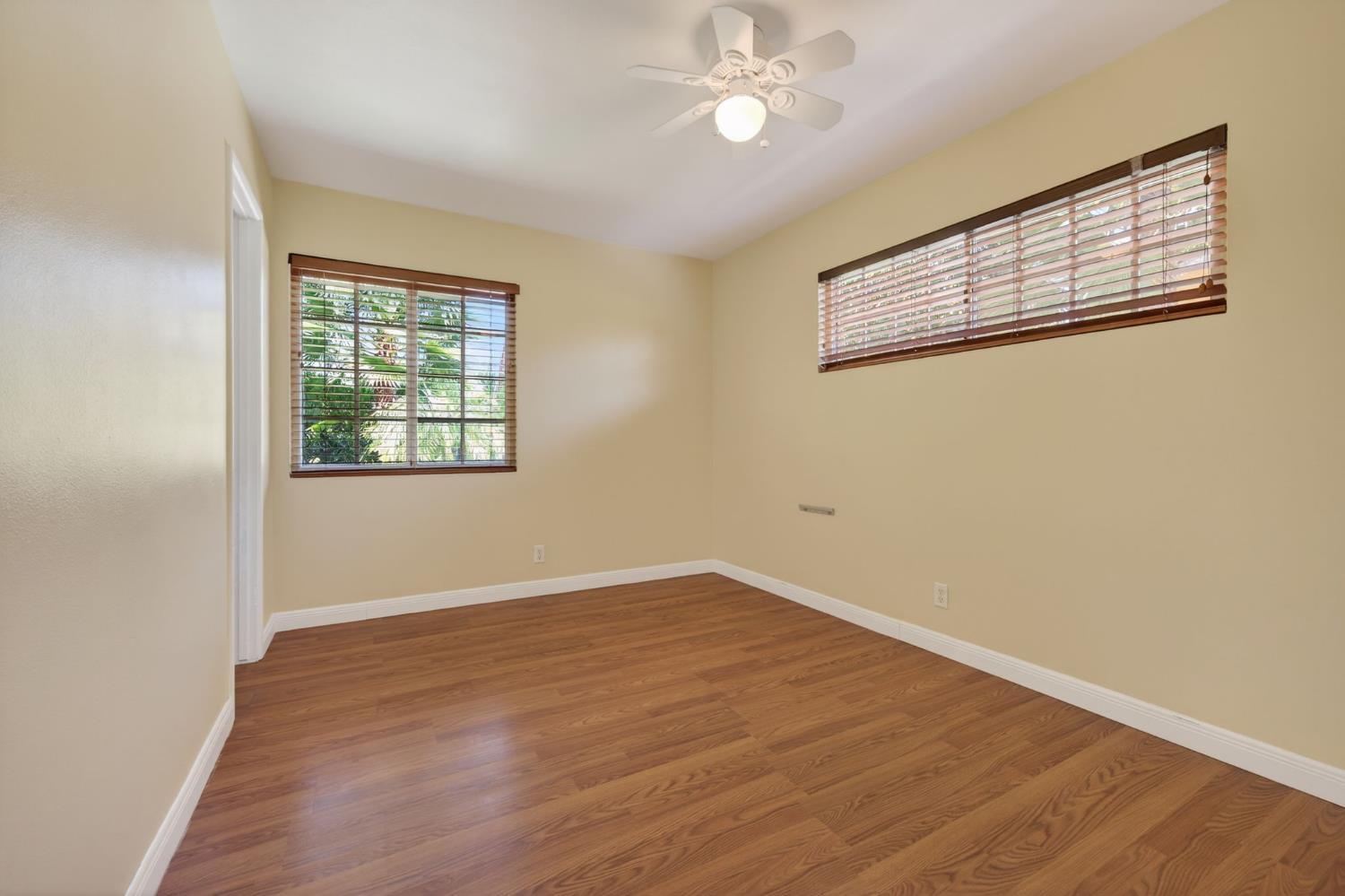 1054 Fairview Road Ojai, CA 93023 - Photo 25 of 33 an empty room with wooden floor chandelier fan and windows