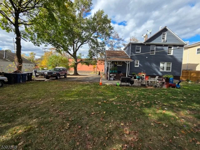 a view of a big house with a big yard and large trees