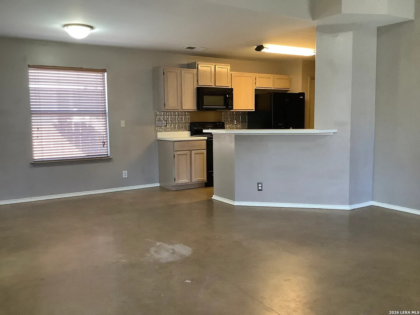 9502 Swans Crossing San Antonio, TX 78250 - Photo 5 of 17 a view of an empty room with a window and a kitchen