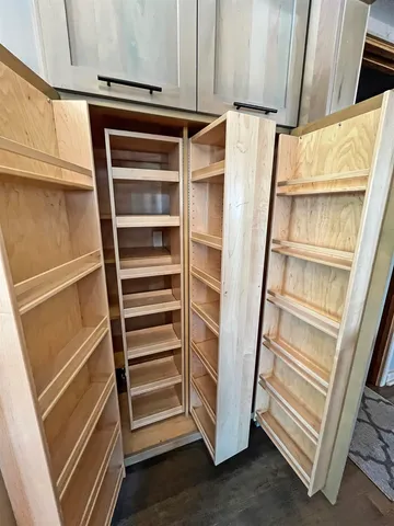 a view of walk in closet with empty racks