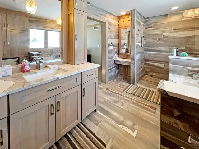 a spacious bathroom with double vanity and a mirror
