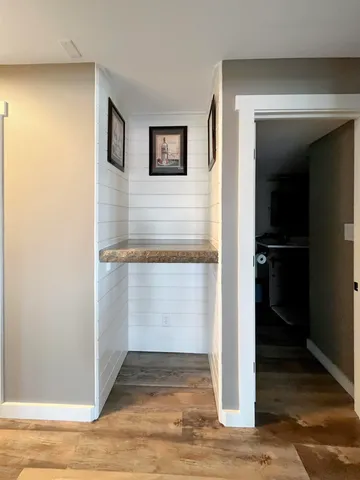 a view of a hallway with wooden floor and closet