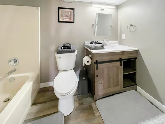 a bathroom with a toilet sink and mirror