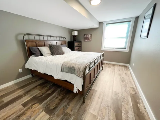 a bedroom with a bed and wooden floor