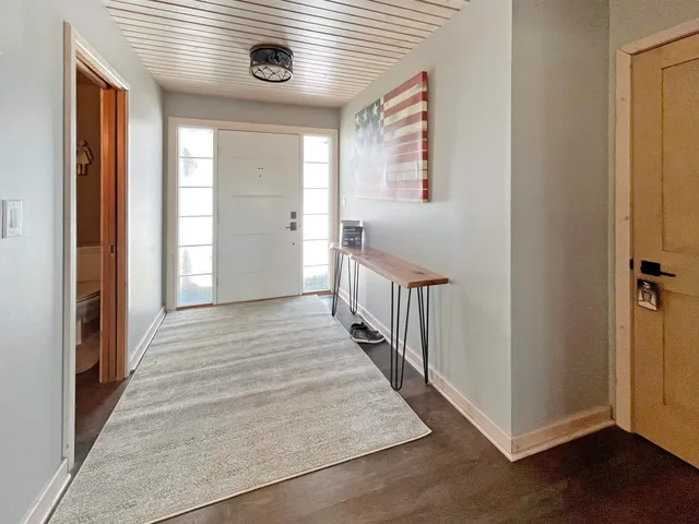 a view of a hallway with wooden floor and staircase