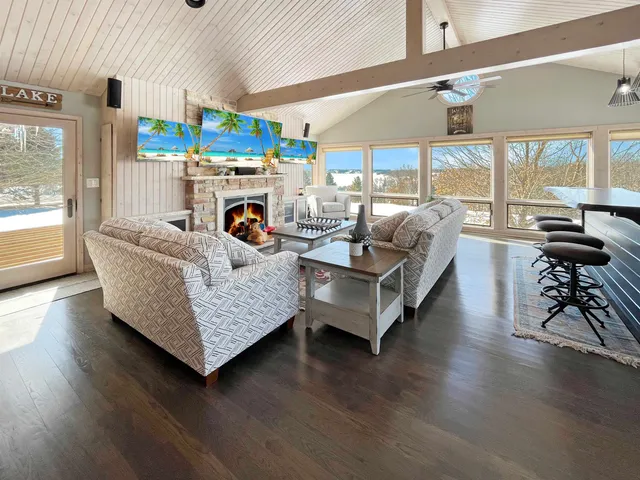 a living room with furniture fireplace and a large window