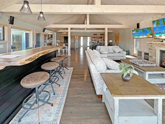 a dining room with stainless steel appliances granite countertop a dining table chairs and couches