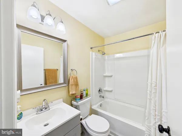 a bathroom with a bathtub shower sink vanity and toilet