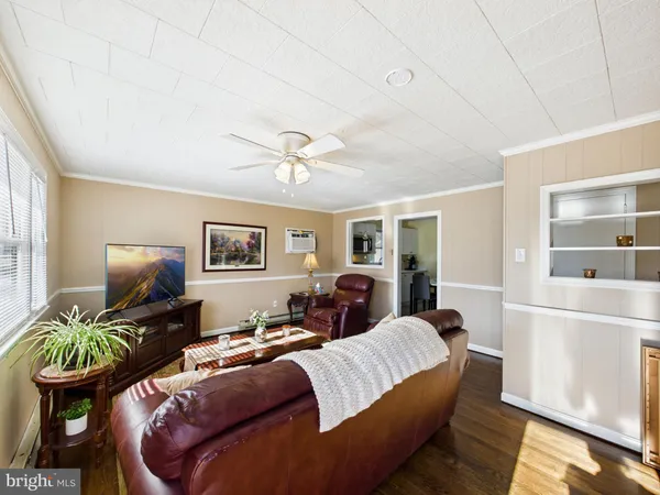 a living room with furniture a chandelier and a flat screen tv