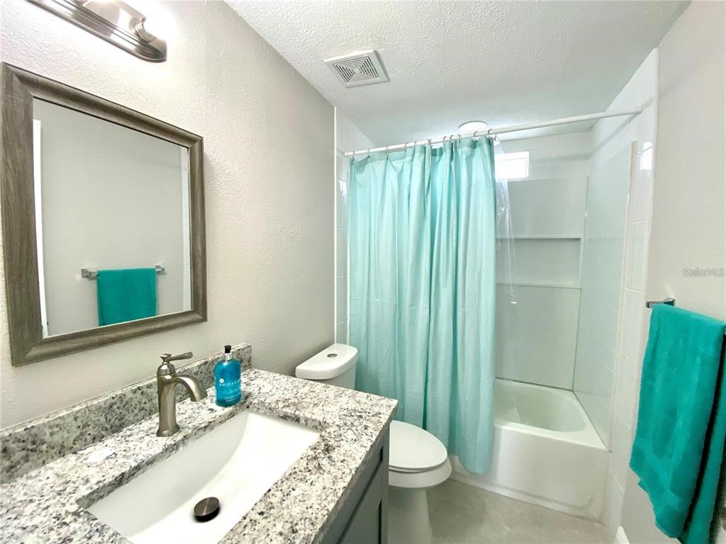 8726 Mayflower Road Tampa, FL 33615 - Photo 3 of 7 a bathroom with a granite countertop sink toilet and shower