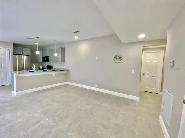 a view of a hallway with kitchen and kitchen island