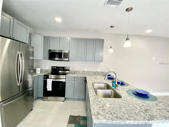 a kitchen with stainless steel appliances granite countertop a sink refrigerator and microwave