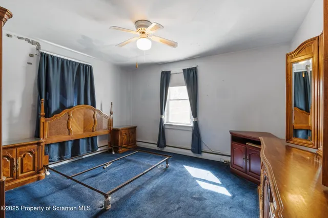 a view of a bedroom with wooden floor and cabinet