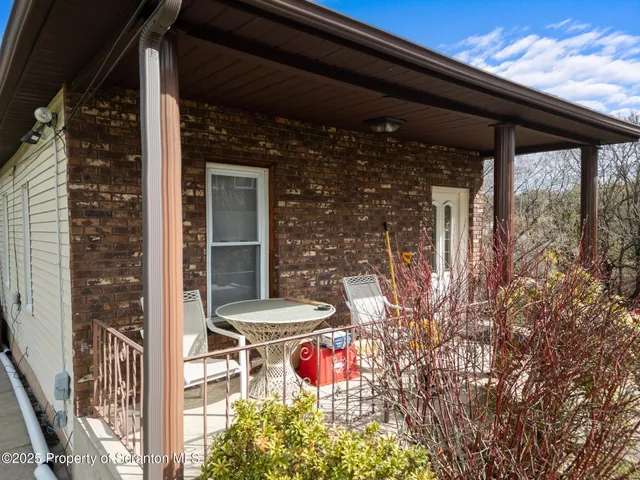 a view of a patio with table and chairs under an umbrella