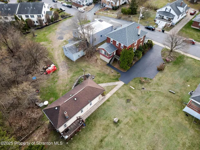 an aerial view of a house with a yard and lake view