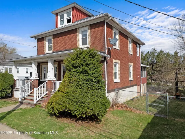 a terrace of a house with barbeque oven and outdoor seating