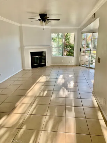 a view of an empty room with a fireplace and a window