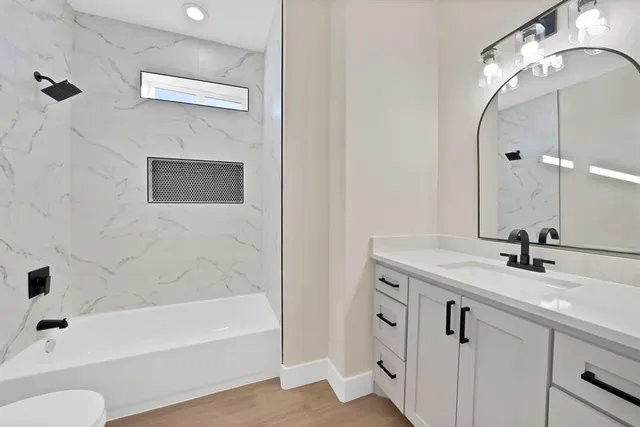 an empty room with wooden floor and window