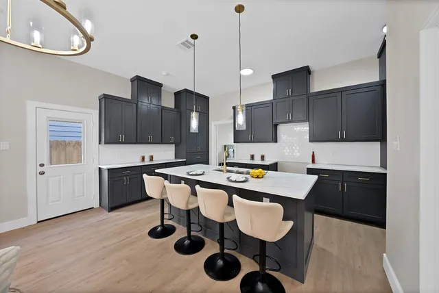 a kitchen with a sink a stove and chairs