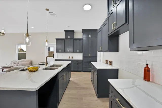 a kitchen with stainless steel appliances kitchen island granite countertop a sink a counter space and cabinets