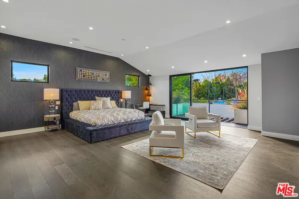 a bedroom with a large bed and a flat screen tv