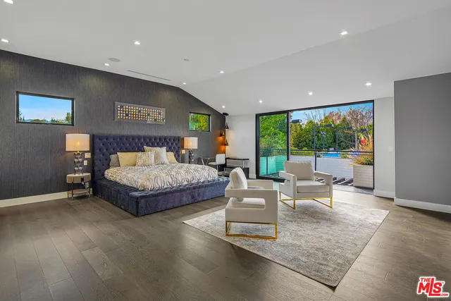 a bedroom with a large bed and a flat screen tv