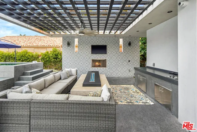 a roof deck with a table and chairs under an umbrella with a barbeque